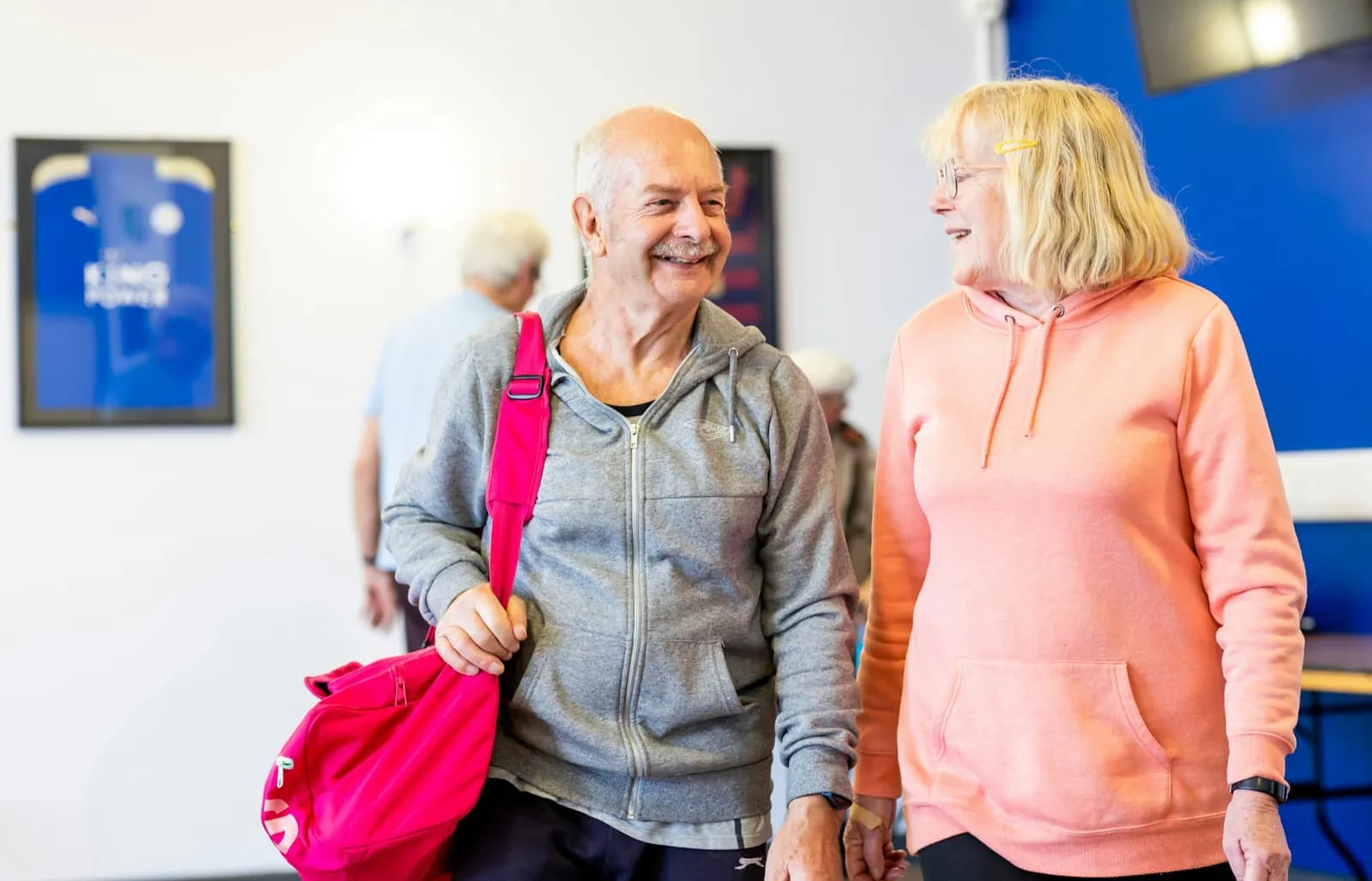 Older couple smiling together at the gym