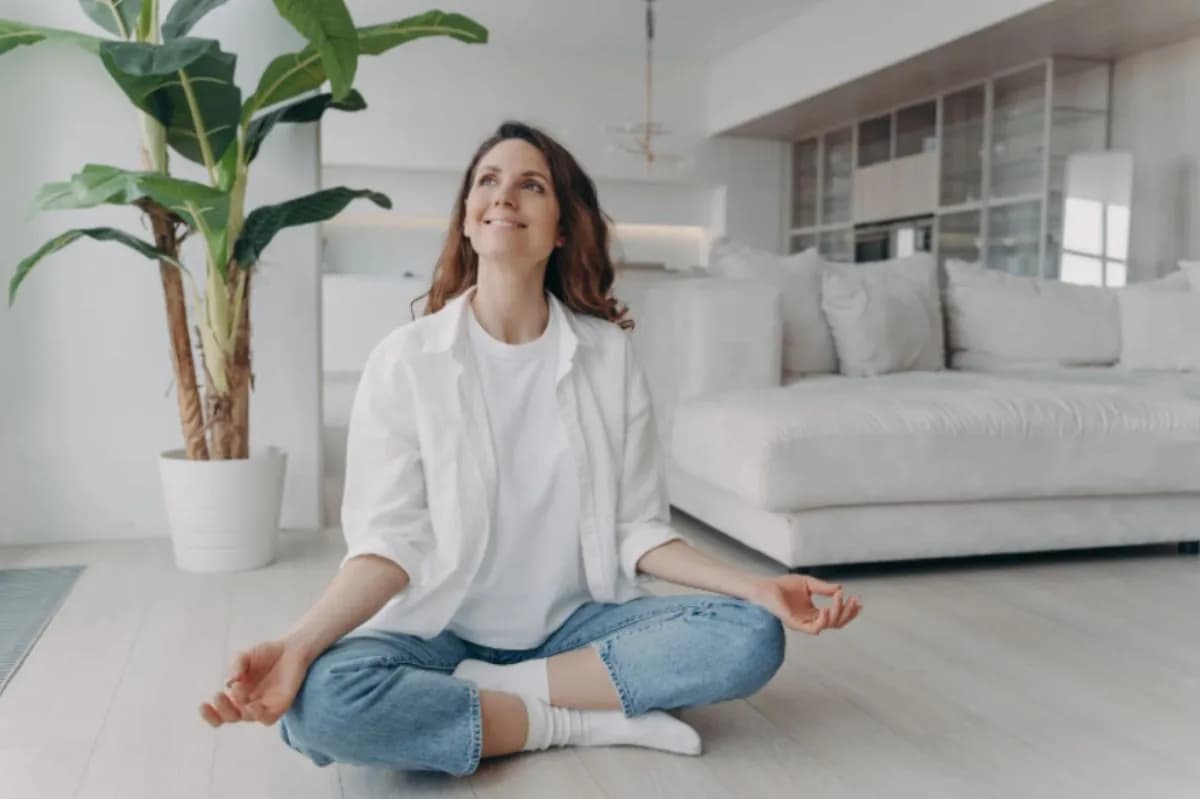 Woman sitting cross-legged and relaxed in a bright living room