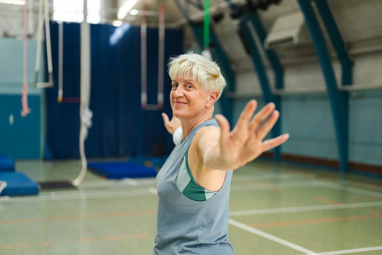 Older woman exercising in a community sports hall