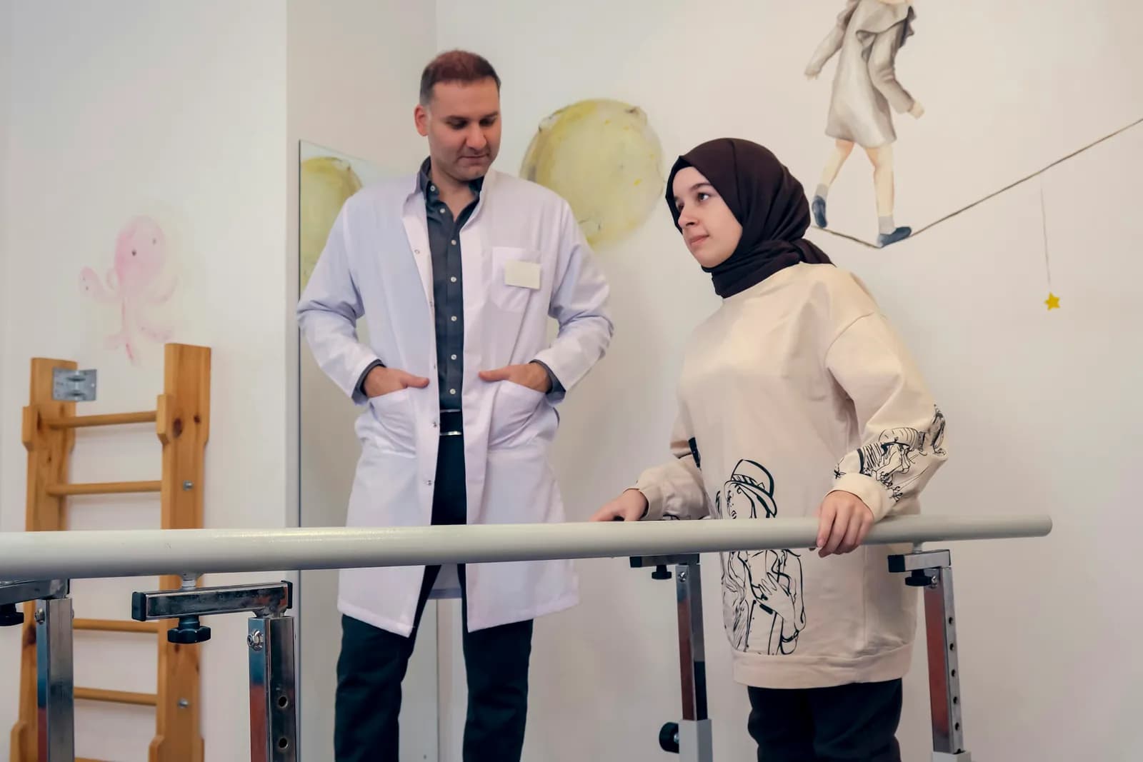 Woman walking between parallel bars with a clinician beside her