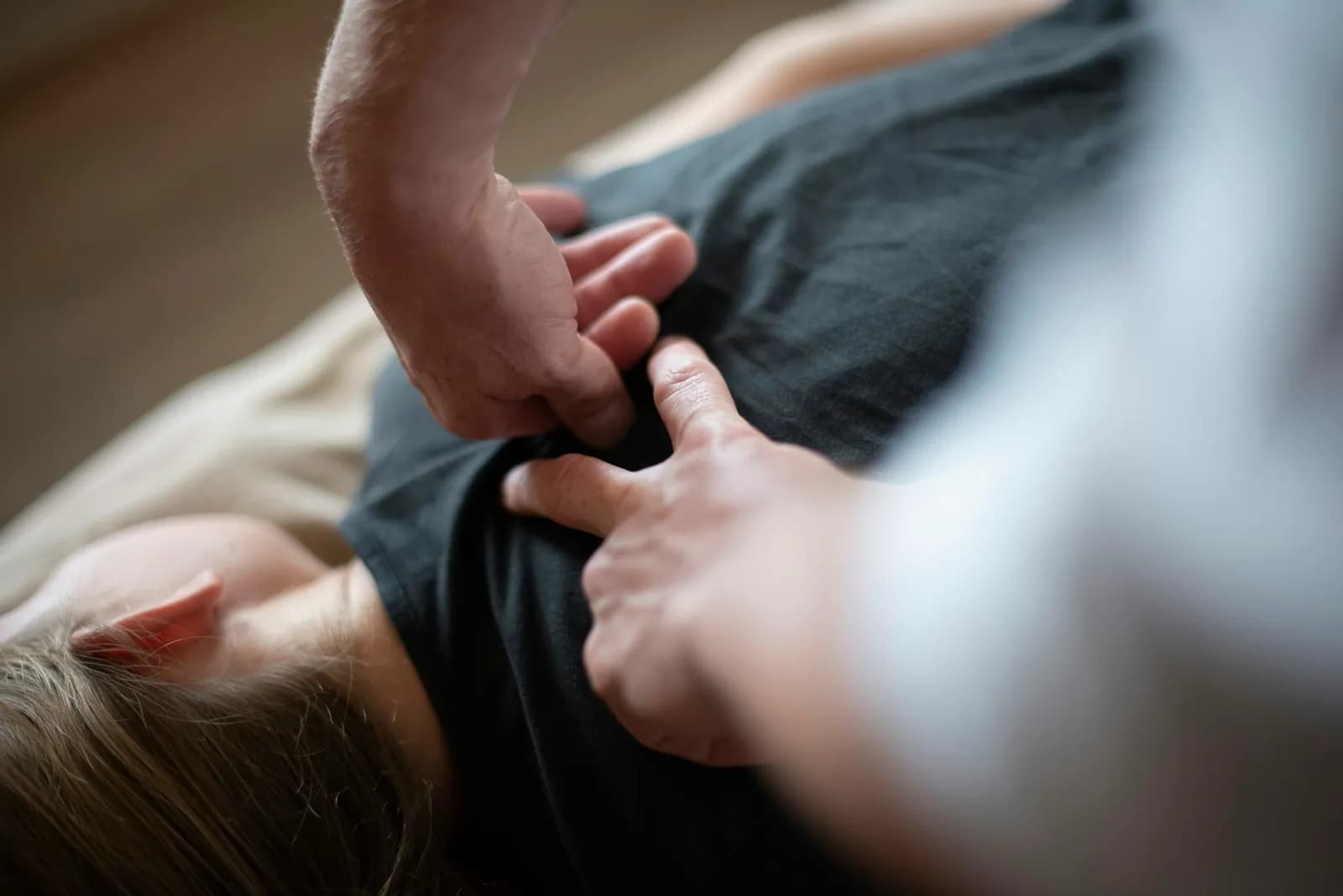 Hands-on treatment to the upper back of a patient lying face down