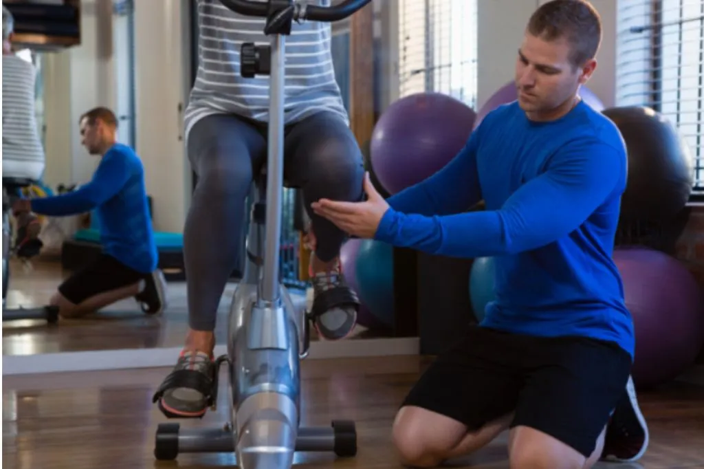 Exercise physiologist coaching a client on an exercise bike