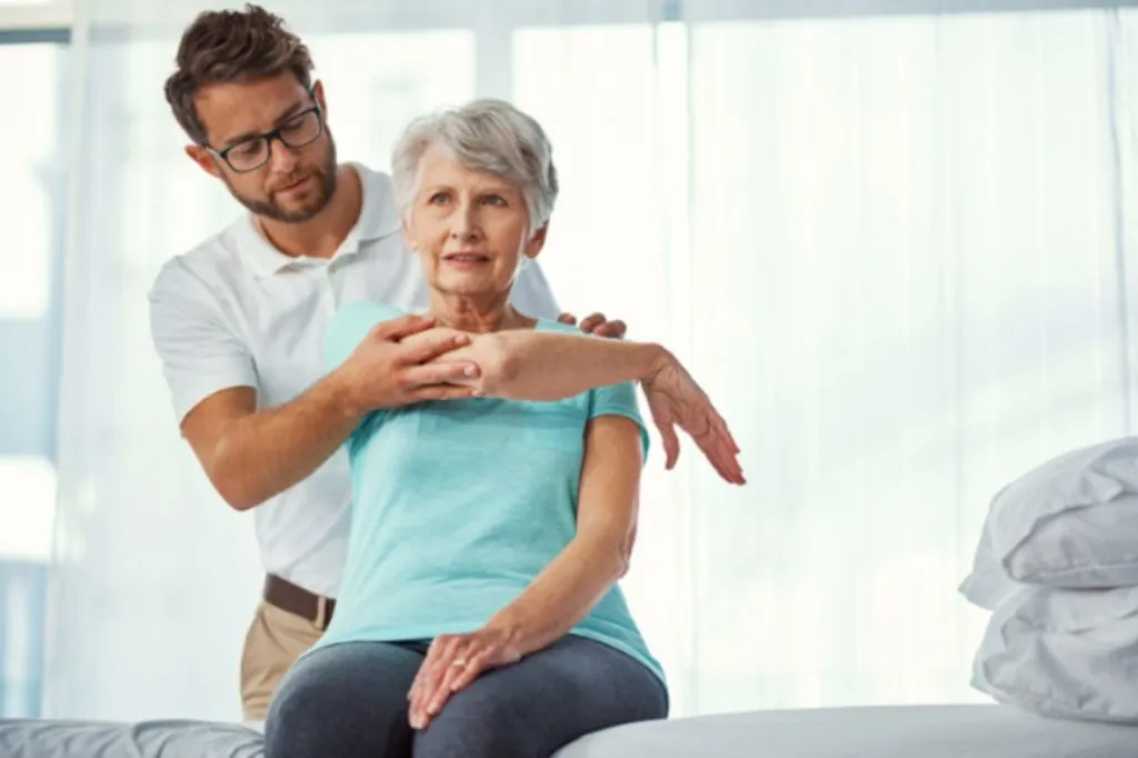 Exercise physiologist guiding an older woman's arm exercise